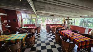 a restaurant with tables and chairs in a room at Hotel y Cabañas Manolo in El Pedregal
