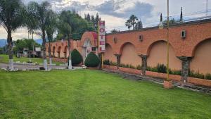a building with a green lawn in front of it at Hotel y Cabañas Manolo in El Pedregal