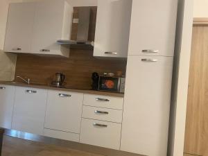 a kitchen with white cabinets and a microwave at B&B Airport 26 in Azzano San Paolo