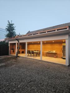 a house with a covered patio with a table and chairs at V-House in Vama Buzăului
