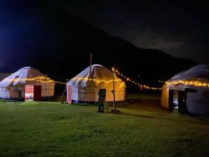 two domes with lights in a field at night at Aalam yurt camp Altyn-Arashan in Mineralʼnyy Istochnik Altyn-Arasan