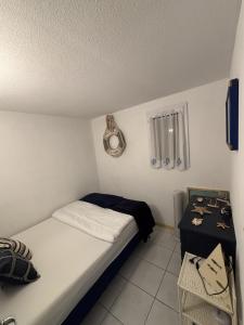 een kleine slaapkamer met een bed en een tafel bij Pavillon de vacances chic et moderne in Plage dʼArgelès