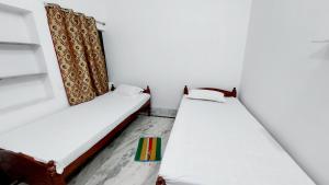 two beds in a room with a curtain at Nilam Guest House in Bodh Gaya