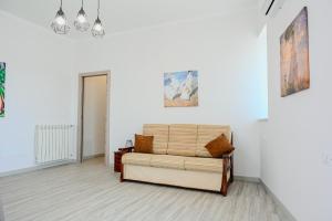 un salon avec un canapé et des tableaux au mur dans l'établissement Il Rifugio di Eva, à Alberobello