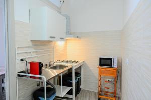 une petite cuisine avec un évier et un micro-ondes dans l'établissement Il Rifugio di Eva, à Alberobello