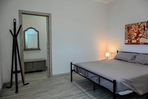 une chambre avec un grand lit et un miroir dans l'établissement Il Rifugio di Eva, à Alberobello 23 autres photos