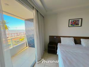 a bedroom with a bed and a view of the ocean at Blue Sunset Frente Mar Cabo Branco-Miramar Hospedagens in Penha +30 photos