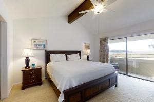 Amelia Island Plantation townhome with amazing marsh views, WiFi & shared pool في Franklintown: غرفة نوم مع سرير مع مروحة سقف ونافذة