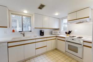 Amelia Island Plantation townhome with amazing marsh views, WiFi & shared pool في Franklintown: مطبخ بدولاب أبيض وأجهزة بيضاء