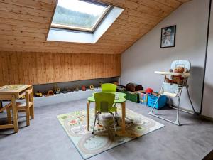a attic room with a skylight and a table and chairs at Grande maison au cœur des Vosges, escapades et nature - FR-1-583-466 in Belfahy