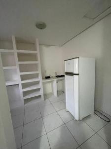a kitchen with a white refrigerator and a shelf at Casa na Suíça baina in Vitória da Conquista +5 photos