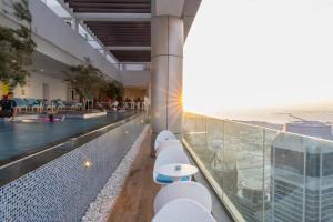 a hotel with a swimming pool and a view of the ocean at 49th Floor 2BR Corner Apt with Burj Khalifa View and Infinity Pool Access in Dubai