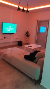 a living room with a couch and a table and a tv at Luxurious apartment Lina in Hiboun