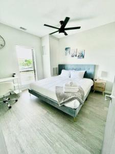 a bedroom with a large bed with a ceiling fan at Skyline Solace in Des Moines