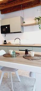 a kitchen with a table with bowls on it at Dimora Muneghette 181 by ApartSuite in Chioggia +20 photos