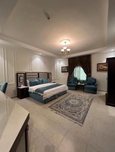a large bedroom with a bed and a couch and chairs at شقق الحنوة للوحدات السكنية in Sakakah