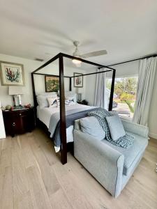 a bedroom with a canopy bed and a couch at Aylees Siesta Key Beach House-360 steps from beach-Saltwater Pool-Pet Friendly in Siesta Key +47 photos