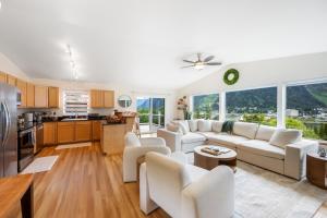 a living room with white furniture and a kitchen at Magical Mountain Retreat in Juneau
