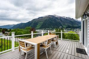 a table and chairs on a deck with a mountain at Magical Mountain Retreat in Juneau