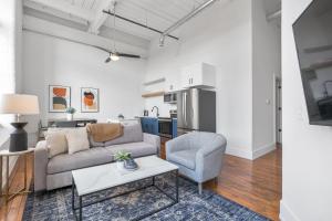 ein Wohnzimmer mit einer Couch, einem Sessel und einem Tisch in der Unterkunft Landing Apartments - Greenville in Greenville
