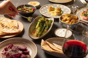a table topped with plates of food and bowls of food at Hotel Indigo Leeds by IHG in Leeds +117 photos