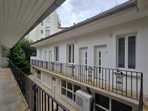 un balcone di un edificio bianco con recinzione di 3D- Studio tout équipé avec cuisine 10 mins de Paris a Issy-les-Moulineaux