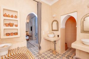 a bathroom with two sinks and two mirrors at Riad GUENAOUA Jacuzzi & Rooftop in Marrakesh +171 photos