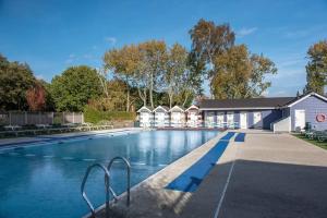 a large swimming pool with a building in the background at Lovely 6 berth caravan Haven wild duck hoilday park in Belton