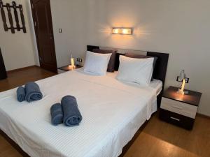 Un dormitorio con dos camas con toallas azules. en Апартамент Созополски Залез, en Sozopol