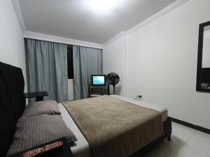 a bedroom with a bed and a television in it at Casa Belmonte Pereira, Amplia, con Garaje y cerca a ExpoFuturo in Estación El Salto
