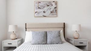 PalmettoにあるLanding Palmetto Apartmentsのベッドルーム1室(ナイトスタンド2つ、ランプ2つ付)