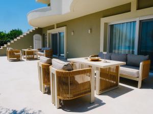 a patio with wicker chairs and a table at Villa Naval in Nea Peramos