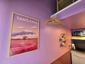 a kitchen with purple walls and a poster of a mountain at 3G- Studio tout équipé avec cuisine proche Paris in Issy-les-Moulineaux +17 photos
