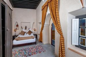 a bedroom with a bed and a window with curtains at Riad GUENAOUA Jacuzzi & Rooftop in Marrakesh