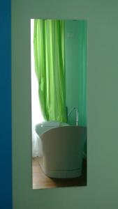 a bathroom with a tub with a green shower curtain at B&B Casa Fenoglio in Ventimiglia
