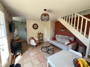 a living room with a couch and a staircase at O'Pale House proche Touquet in Camiers