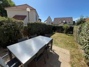 a stainless steel table and chairs in a yard at O'Pale House proche Touquet in Camiers