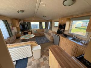 eine Küche und ein Wohnzimmer eines Wohnwagens in der Unterkunft 8 Berth Caravan in Chapel St in Chapel Saint Leonards