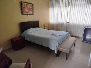 a bedroom with a bed and a table and a chair at Aeropuerto vip in Huanchaco