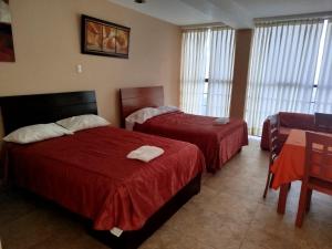 a hotel room with two beds and a table at Aeropuerto vip in Huanchaco