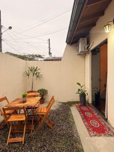 a wooden table and chairs on the side of a house at Suíte Privativa in Florianópolis