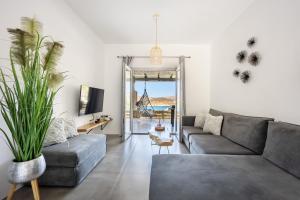 a living room with a couch and a table at Nefeli Residence & Suite Ftelia beach Mykonos in Elia