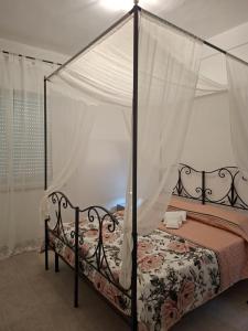 a bedroom with a bed with a canopy at Casa Vacanze Regina in Marsala