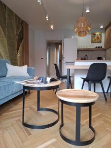 two tables in a living room with a blue couch at Boho Apartment - 100m from Market Square in Wrocław