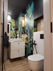 a bathroom with a white toilet and a sink at Boho Apartment - 100m from Market Square in Wrocław +30 photos