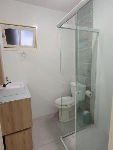 a bathroom with a toilet and a glass shower at Lindo apto 3 quartos todo novo in Torres +20 photos