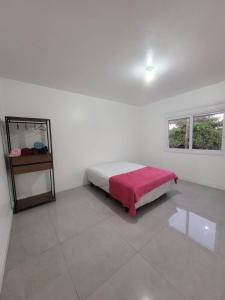 a white room with a bed with a red blanket at Lindo apto 3 quartos todo novo in Torres