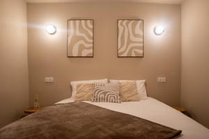 a bedroom with a bed with three pictures on the wall at Play & Chill - Loft Cosy in Hyères