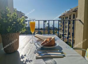a table with a plate of food and a glass of orange juice at La Noria de Alicia in San Luis de Sabinillas