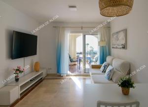 a living room with a couch and a tv at La Noria de Alicia in San Luis de Sabinillas